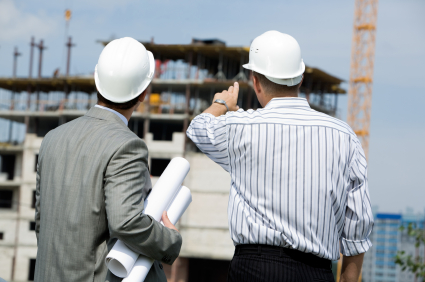 Rear shot of boss pointing at construction with worker near by